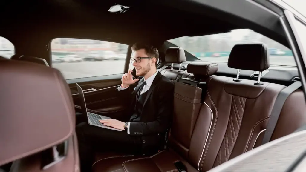 Young businessman talking on smart phone in luxury auto